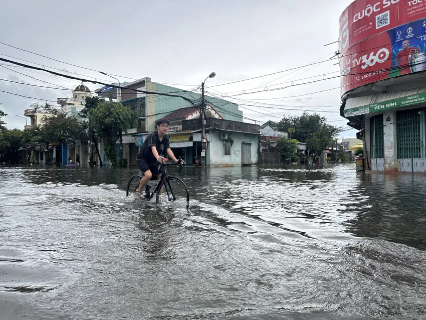 Ngã tư Trần Dư - Huỳnh Thúc Kháng ngập sâu, lực lượng chức năng giăng dây cấm người dân qua lại. Ảnh: TN