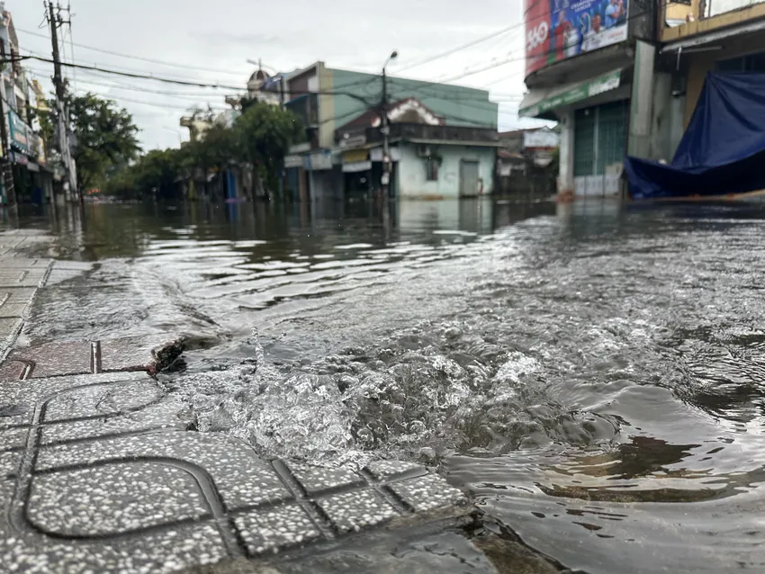 Ngã tư Trần Dư - Huỳnh Thúc Kháng ngập sâu, lực lượng chức năng giăng dây cấm người dân qua lại. Ảnh: TN