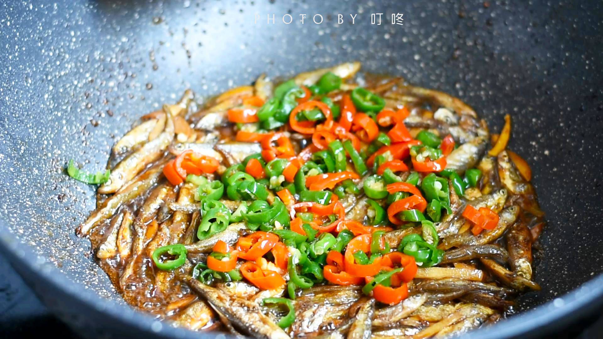 Đổ vào chảo nửa bát nước, đậy nắp và rim trong 1–2 phút để cá thấm vị hơn.