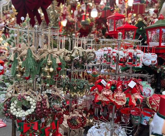 Các món đồ trang trí như vòng nguyệt quế, chuông vàng, nơ đỏ, người tuyết phủ đầy sắc màu lễ hội.