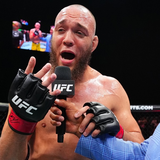 Valter Walker giơ bốn ngón tay, ám chỉ bốn trận thắng liên tiếp bằng đòn khóa chân, sau khi hạ Louie Sutherland. Ảnh: UFC