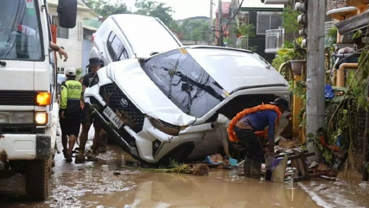 Nhiều phương tiện bị lũ cuốn trôi trong bão. Ảnh: Reuters