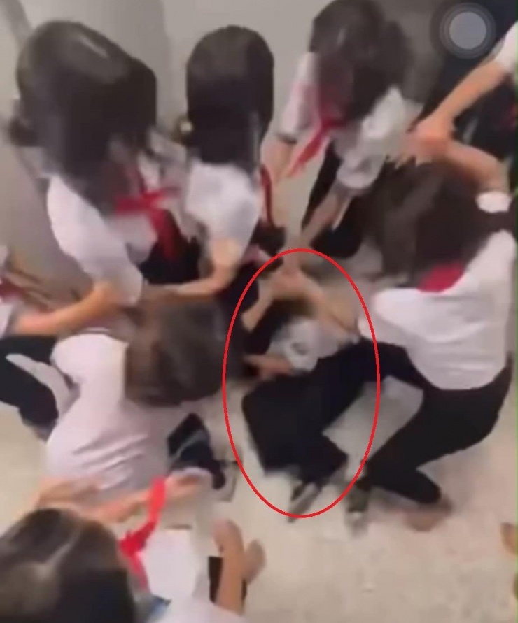 Nạn nhân bị nhóm nữ sinh cùng trường dùng chân đạp liên tục trong khi đang nằm dưới nền nhà