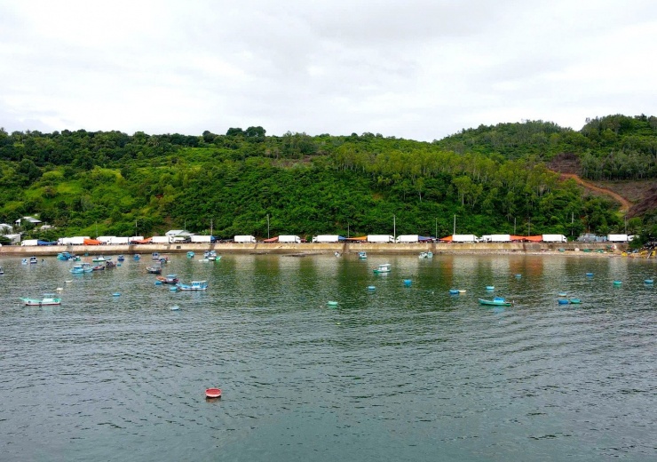 Trên bờ, hàng chục ô tô đông lạnh tới thu mua tôm hùm.