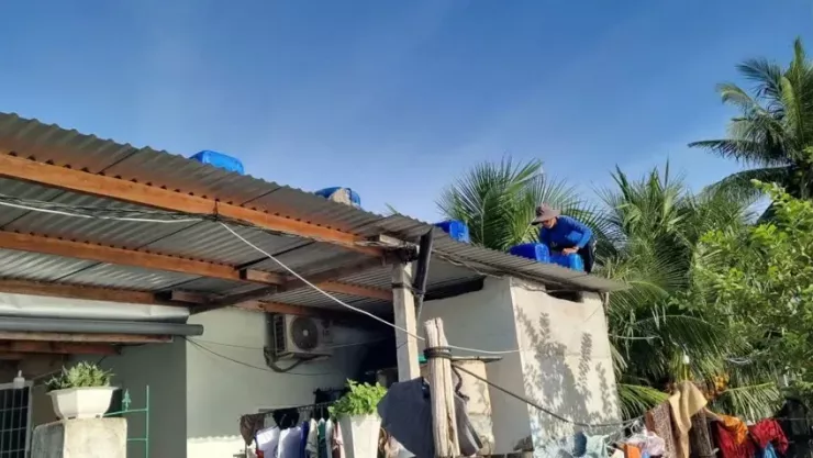 Người dân Đắk Lắk bơm nước vào can nhựa, chèn lên mái nhà. Ảnh: TIẾN THOẠI