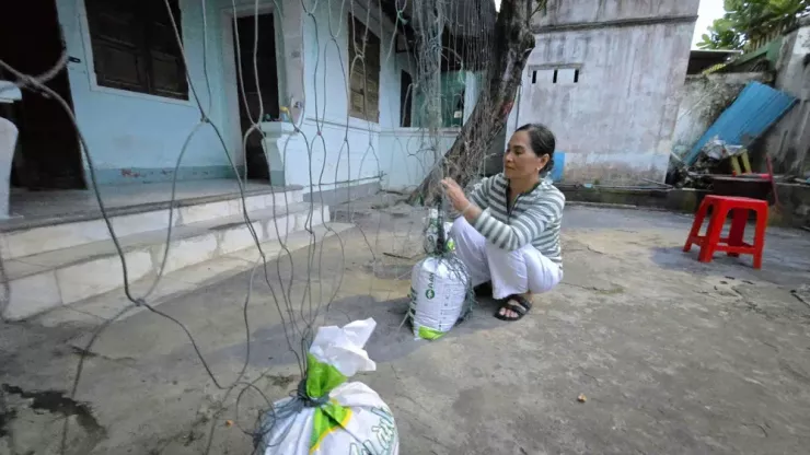 Người dân phường Quy Nhơn Đông dùng bao cát chằng chống nhà cửa, tránh tốc mái nhà khi bão đổ bộ.