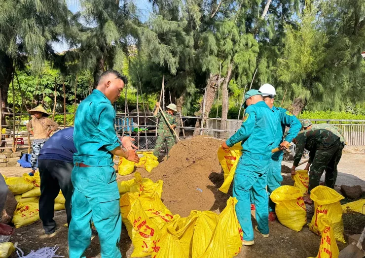 Lực lượng dân phòng cùng người dân xã đảo Nhơn Châu chuẩn bị bao cát, chằng chống nhà cửa khi bão xảy ra.