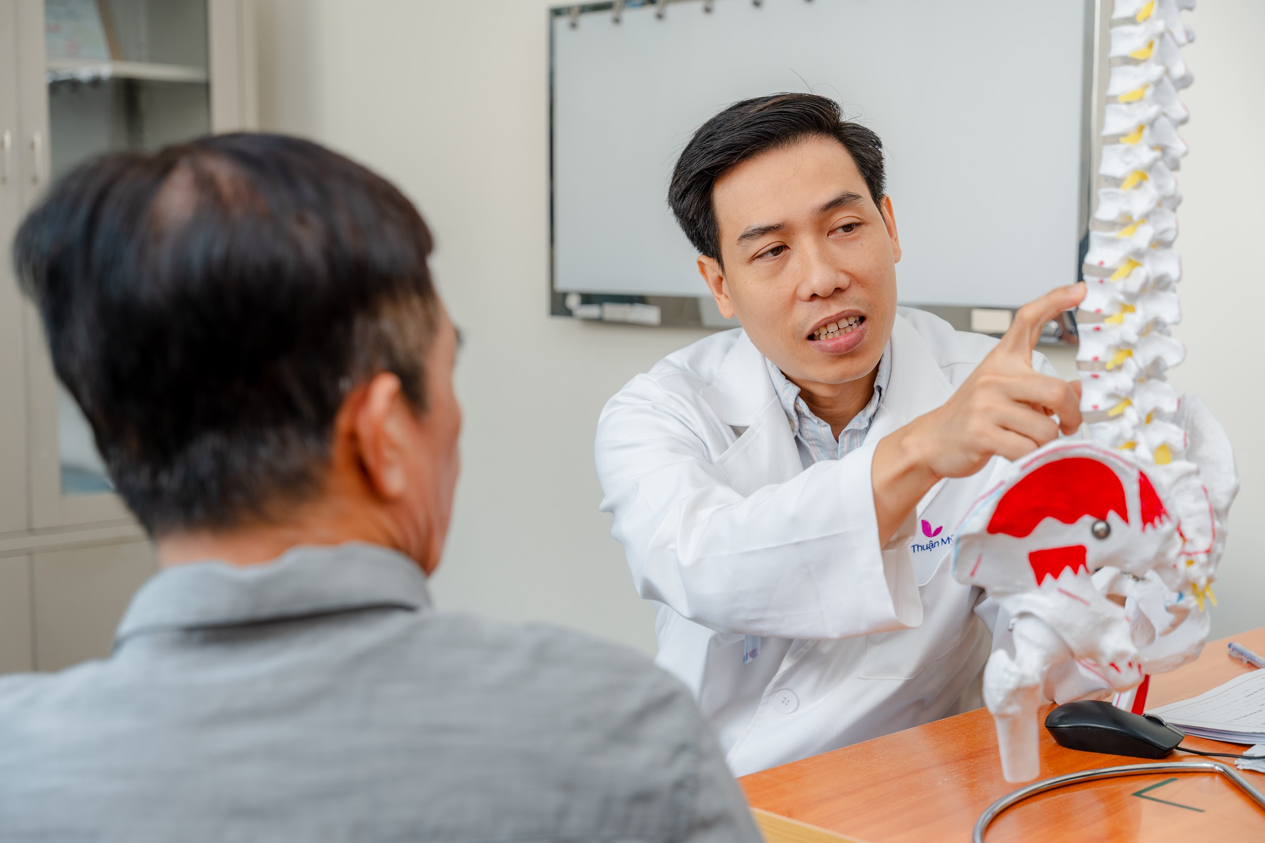 Bác sĩ giải thích cơ chế gây tê đau thắt lưng cho người dân khám sức khỏe tổng quát. Ảnh: BVCC