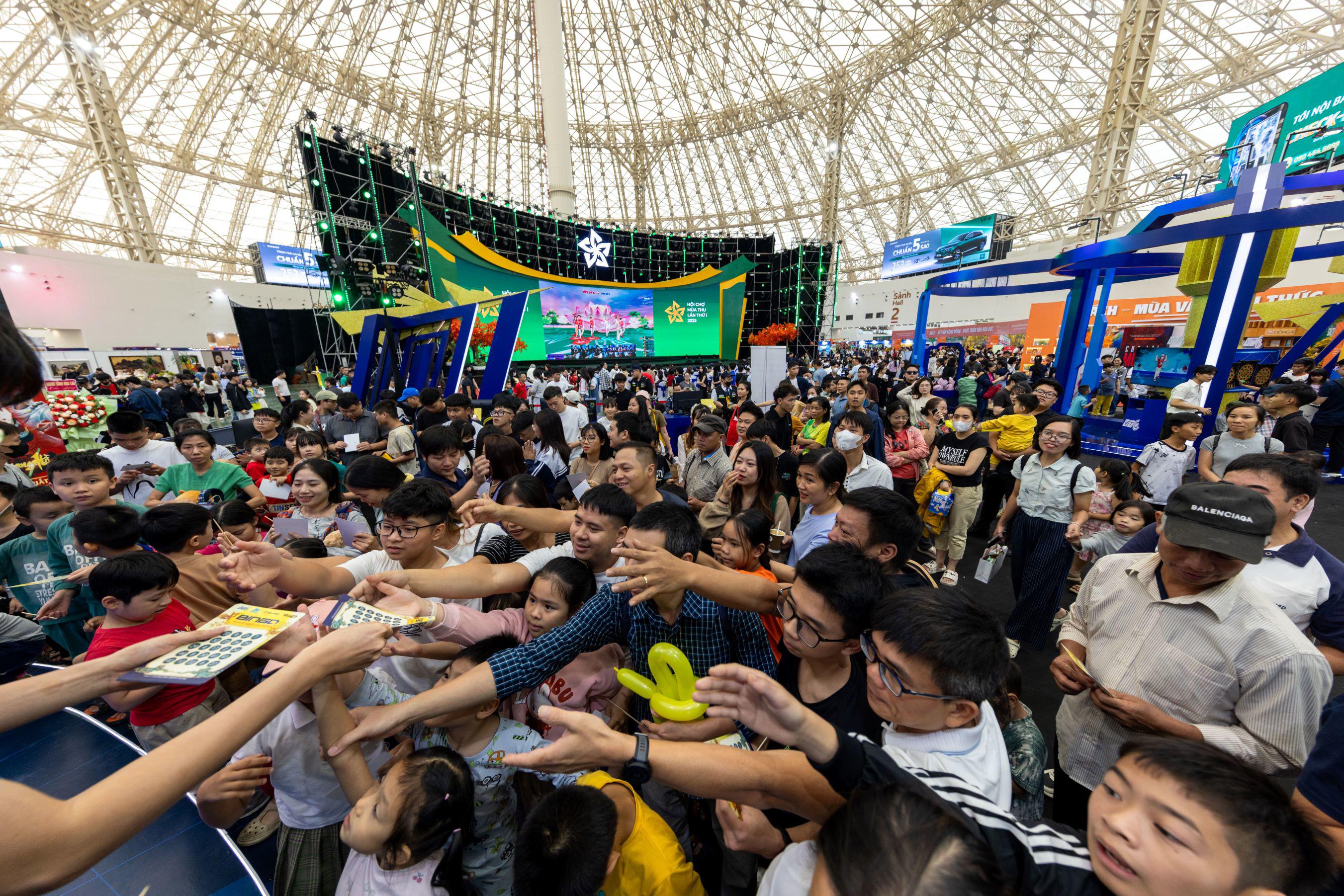 Du khách chen chân tham gia một trò chơi tương tác tại gian hàng trong nhà ở Hội chợ Mùa Thu.