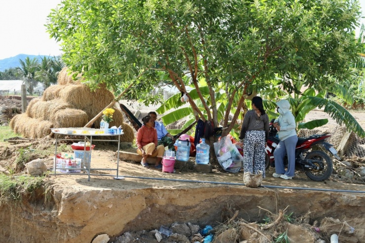 Vợ chồng ông Nguyễn Đáng (ngồi trên võng tạm buộc dưới gốc cây)