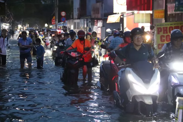Đến 18 giờ 30, nước vẫn ngập sâu, chưa có dấu hiệu rút. Dọc tuyến đường Bình Quới, cuộc sống như ngưng lại. Tiếng máy xe nổ phành phạch xen lẫn tiếng nước chảy . Người lớn, trẻ em bì bõm lội nước về nhà sau giờ tan tầm, còn các quán ăn, cửa tiệm im lìm trong cảnh nước ngập quá đầu gối.