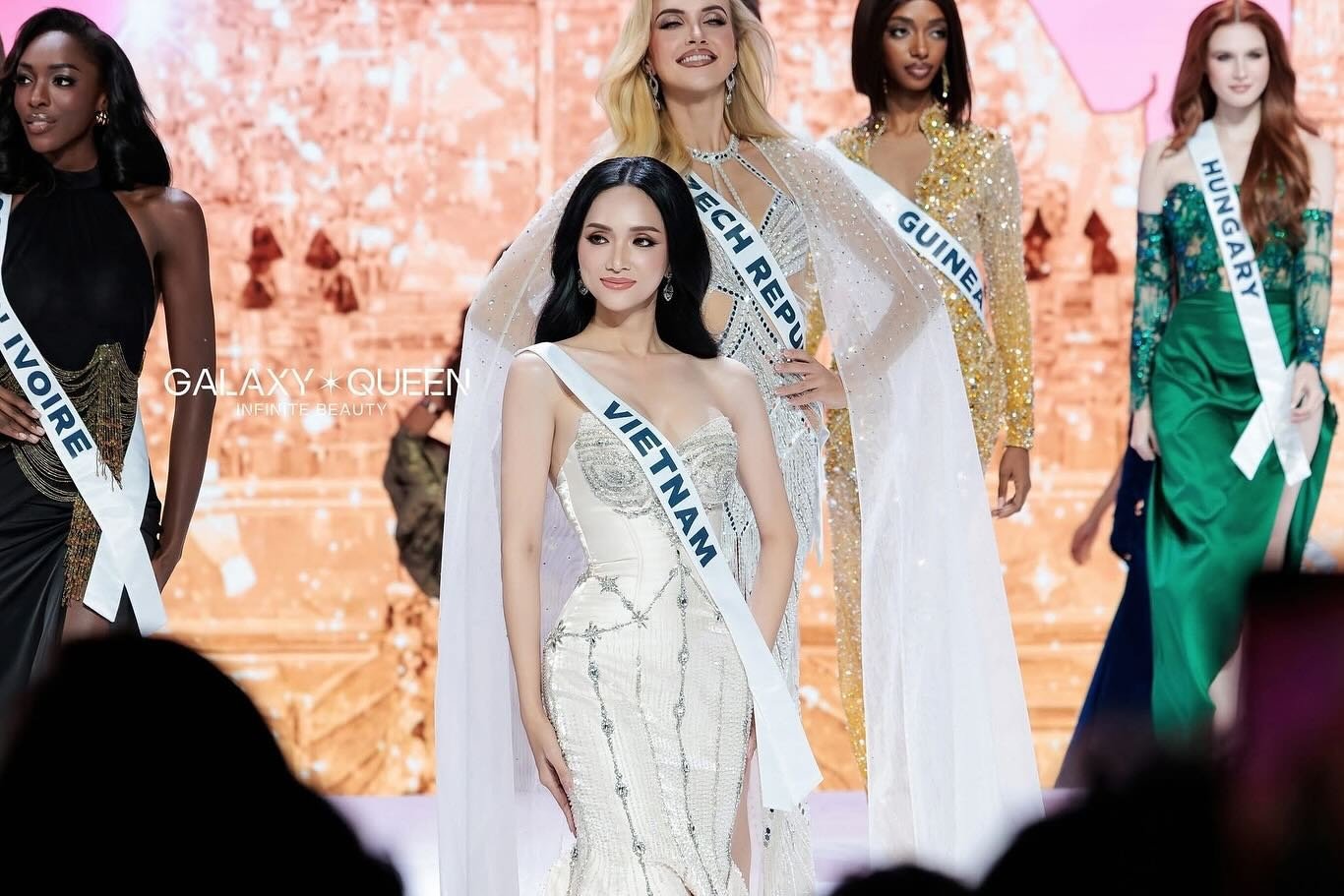 Tham gia Miss Universe 2025, Hương Giang và một số thí sinh chọn trang phục mang gam màu trơn cơ bản là trắng đen hoặc tông trầm, các nàng hậu thể hiện lòng tôn kính với Vương thái hậu Sirikit vừa qua đời ở tuổi 93, nên không chọn các tông màu rực rỡ.
