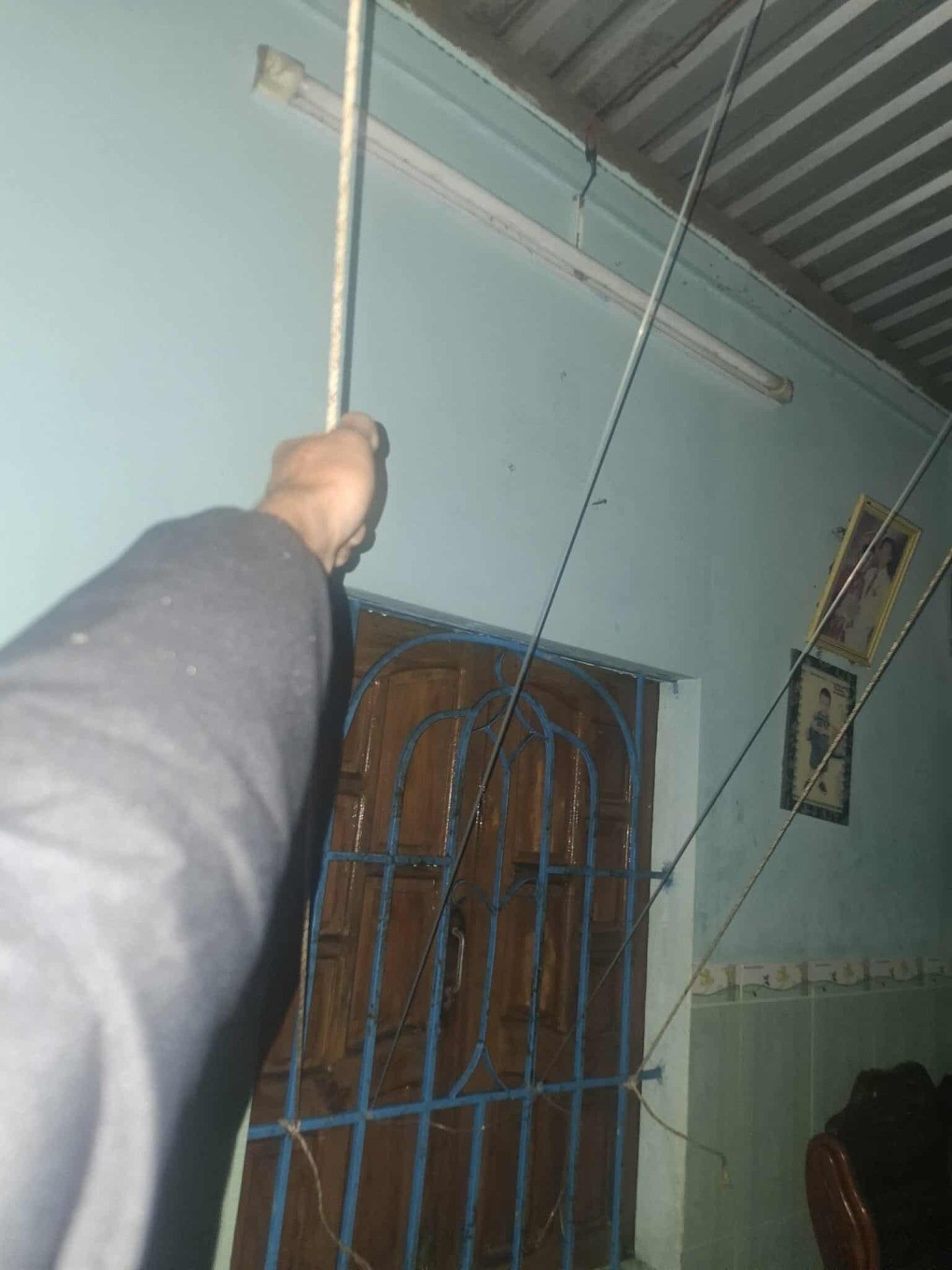 Gia đình anh Mạnh phải dùng dây kéo, giữ mái tôn để tránh gió thổi bay. Ảnh: Văn Mạnh