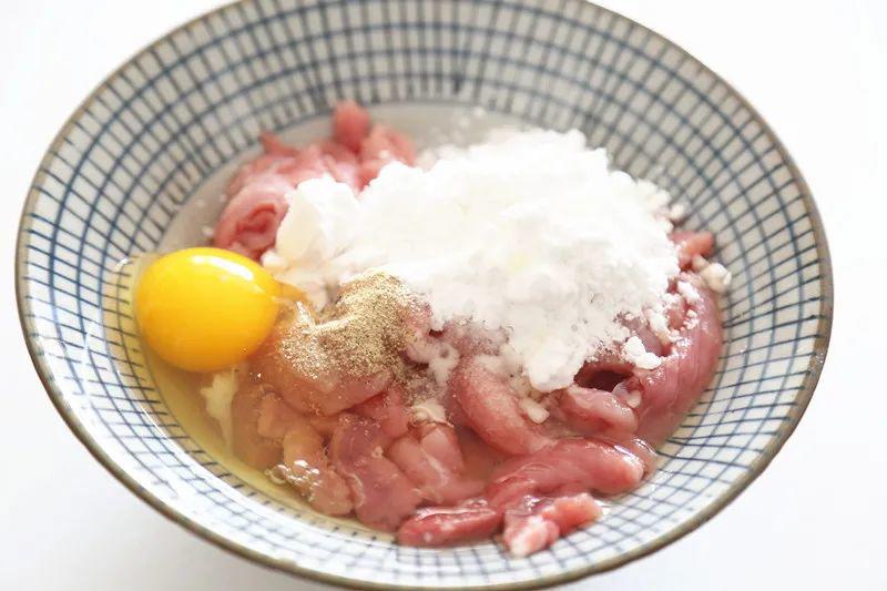 Thái thịt heo thành miếng dài hoặc lát mỏng. Ướp thịt với 1 thìa muối, ít tiêu trắng, nửa thìa rượu nấu ăn, 20g bột bắp, 20g bột mì và 1 quả trứng. Trộn đều cho quyện.