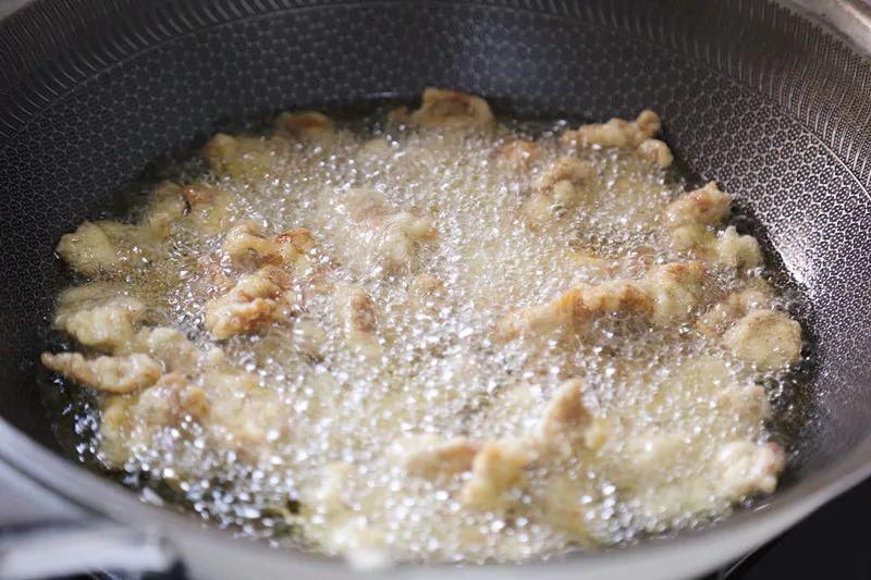 Làm nóng dầu, dùng đũa gắp từng miếng thịt cho vào chiên, tránh đổ cùng lúc khiến thịt dính vào nhau. Chiên đến khi thịt vàng giòn thì vớt ra. 