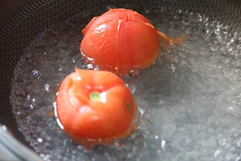 Cà chua rửa sạch, khía hình chữ thập ở đầu quả. Đun nước sôi, cho cà chua vào chần sơ để bóc vỏ dễ dàng, rồi vớt ra ngâm nước lạnh.