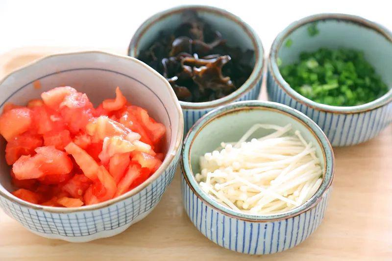 Cà chua bỏ vỏ, thái hạt lựu; mộc nhĩ ngâm nở, thái sợi; nấm kim châm cắt bỏ gốc; hành, gừng, tỏi, ớt và hành lá băm nhỏ để riêng.