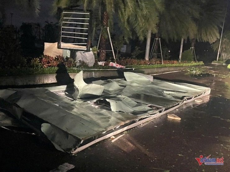 Mái tôn bị gió bão vò biến dạng bay xuống đường. Ảnh: Trần Hoàn