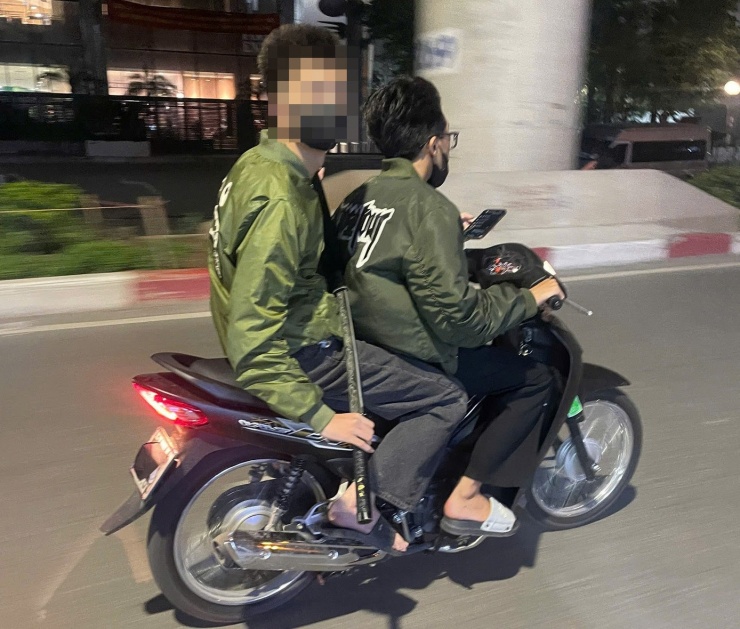 Hình ảnh nam thanh niên cầm theo kiếm trên đường.