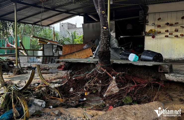 Sóng biển ngoạm vào sát vách hàng quán ven biển, để lại từng mảng bê tông vỡ, mái tôn cong vênh và những khoảng trống loang lổ nơi sóng vừa quét qua.