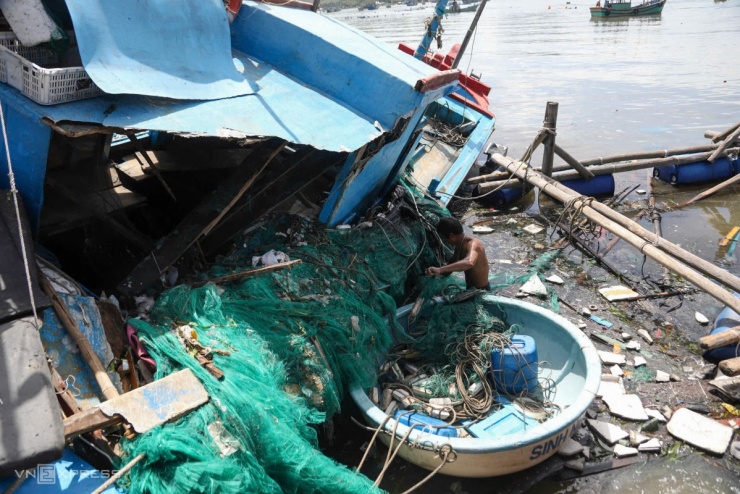 Sáng nay, một số chủ tàu dầm mình dưới biển để vớt lưới, ngư cụ, máy móc lên bờ.