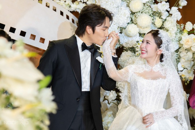 Đình Tú hôn lên tay vợ sau khi đeo nhẫn cưới cho cô.