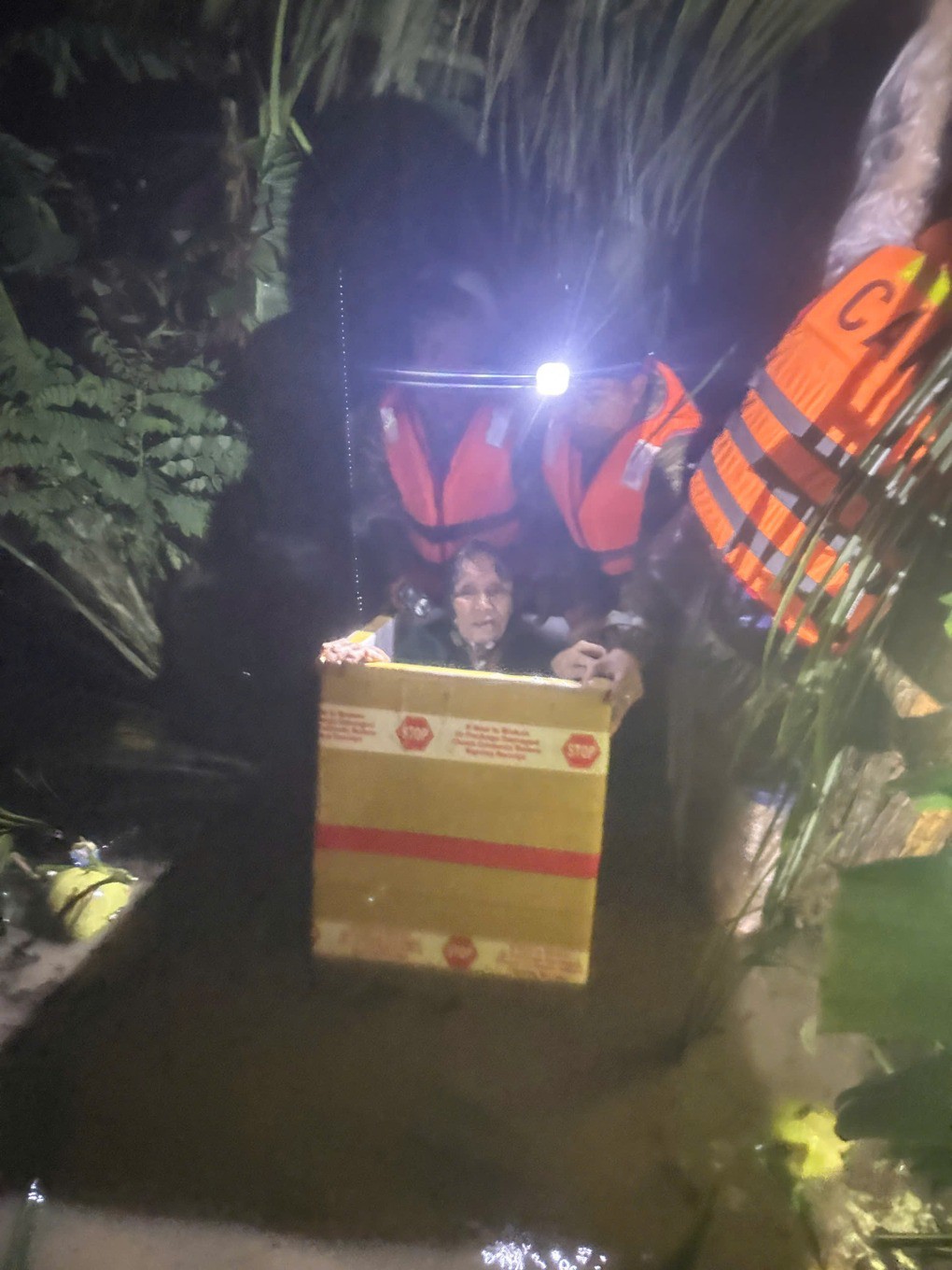 Một cụ già được lực lượng cứu hộ đưa vào thùng xốp di chuyển khỏi điểm ngập. Ảnh: Công an cung cấp