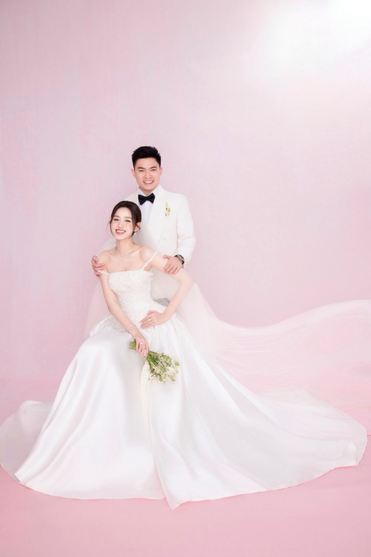 Với concept tông hồng, Hoa hậu Việt Nam 2020 mặc đầm hai dây của NTK Lê Thanh Hòa, còn ông xã Viết Vương diện suit trắng và nơ đen của NTK Kim & Kim.