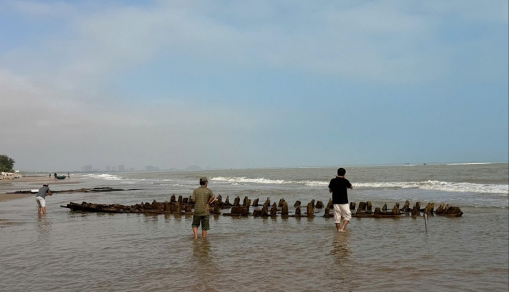 Hình ảnh chiếc tàu cổ trồi lên giữa bãi biển Hội An khiến du khách và người dân tò mò.