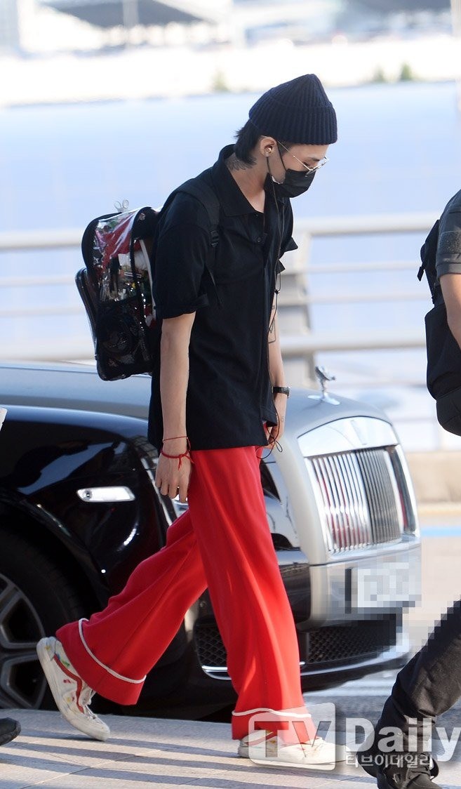 Thời trang sân bay của G-Dragon với áo polo và quần ngủ màu đỏ. Ảnh: TV Daily