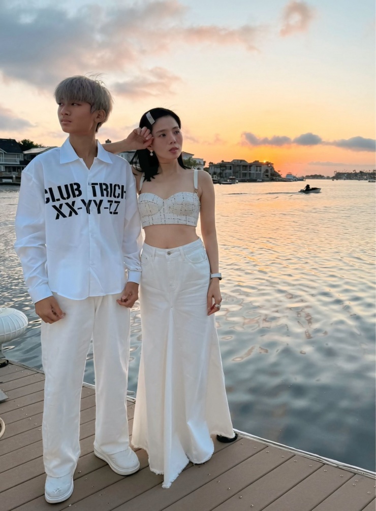 Cũng trong chuyến đi này, khi ngắm hoàng hôn bên sông, Kỳ Anh diện cả bộ màu trắng đồng điệu với mẹ, mang giày Louis Vuitton.