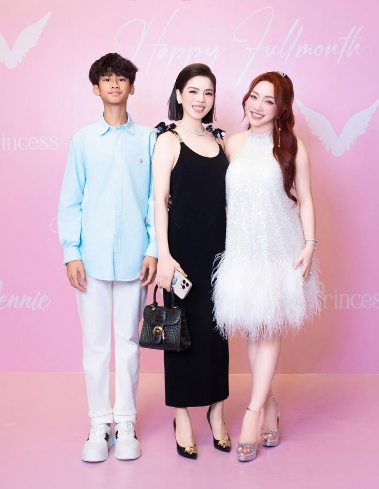 Mẹ con ca sĩ Lệ Quyên tới tiệc mừng thôi nôi của con gái vợ chồng Chi Bảo, Thùy Chang năm ngoái. Ca sĩ chọn đầm và giày của Versace, Kỳ Anh diện sơ mi xanh nhạt của Ralph Lauren, phối quần ống côn và sneakers.