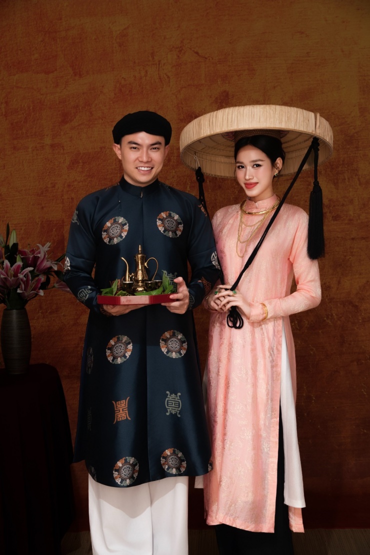 Doanh nhân Viết Vương đội khăn xếp, diện áo dài mang các biểu tượng của trường thọ, may mắn, bưng đĩa đựng trà và trầu cau.