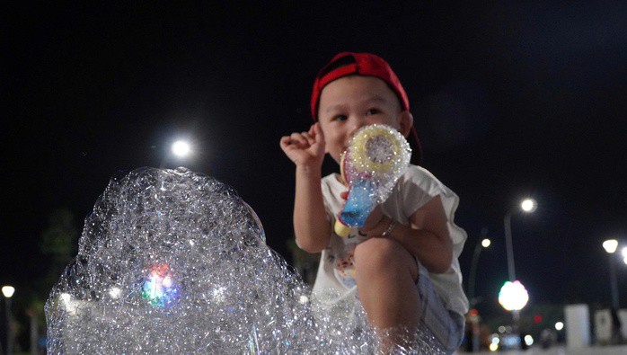 Một em nhỏ được cha mẹ dẫn đến quảng trường Phan Ngọc Hiển để vui chơi, giải trí