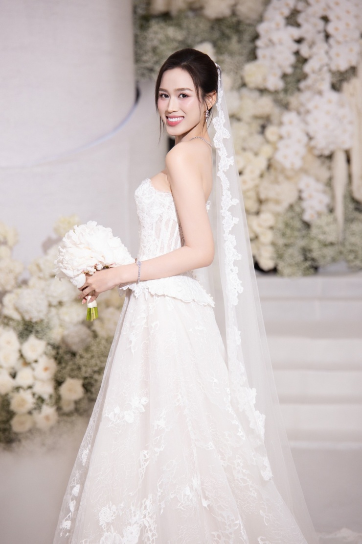 Tiếp tục ứng dụng phom corset siết eo trên nền chất liệu ren mỏng manh, NTK Phương Linh khéo xử lý để giúp Đỗ Thị Hà tôn ngực đầy và vòng eo 'con kiến'. Chiếc váy được chỉnh sửa nhiều lần, nhằm phù hợp với cân nặng, số đo thay đổi của hoa hậu trước lễ cưới.