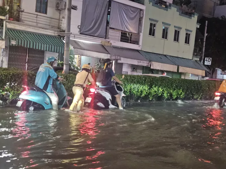 Lực lượng CSGT TP.HCM hỗ trợ người dân đi qua vùng ngập vào tối ngày 6-11.