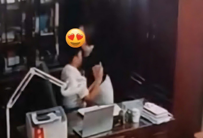 Hình ảnh người đàn ông "thân mật" với người phụ nữ trong phòng làm việc. Ảnh cắt từ clip