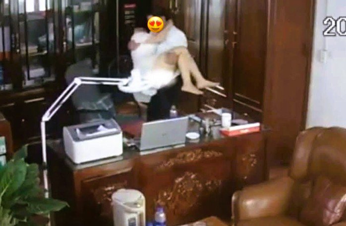 Hình ảnh người đàn ông có hành động "thân mật" với một phụ nữ trong phòng làm việc. Ảnh cắt từ clip