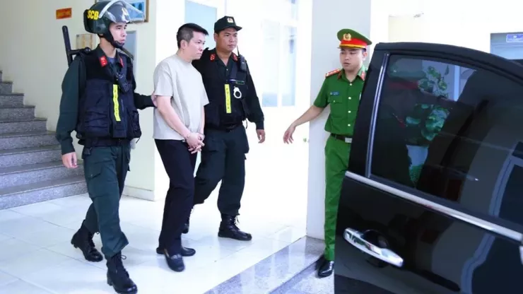 Bị can Nguyễn Quốc Vũ được cơ quan công an áp giải ra xe. Ảnh: CA.