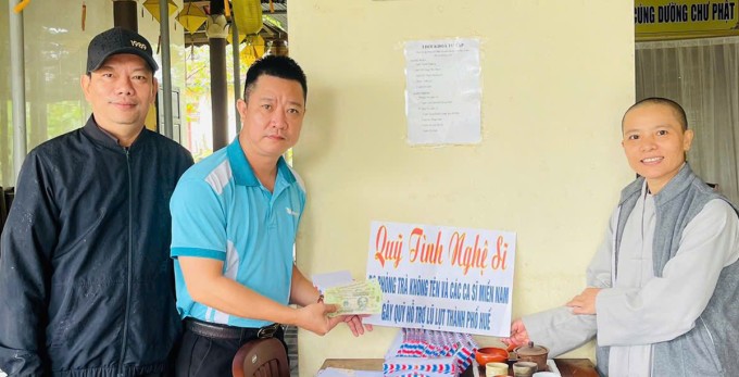 Nhóm tình nguyện viên thay mặt Đàm Vĩnh Hưng hỗ trợ tiền cho người dân ở Huế. Ảnh: Nhân vật cung cấp