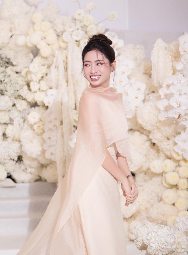 Chưa hết, Lương Thùy Linh diện bộ váy màu be rất thanh lịch, sang trọng tới đám cưới Hoa hậu Đỗ Thị Hà. Đây là một thiết kế của local brand có tiếng và ai cũng khen Miss World Vietnam 2019 có gu ăn mặc.