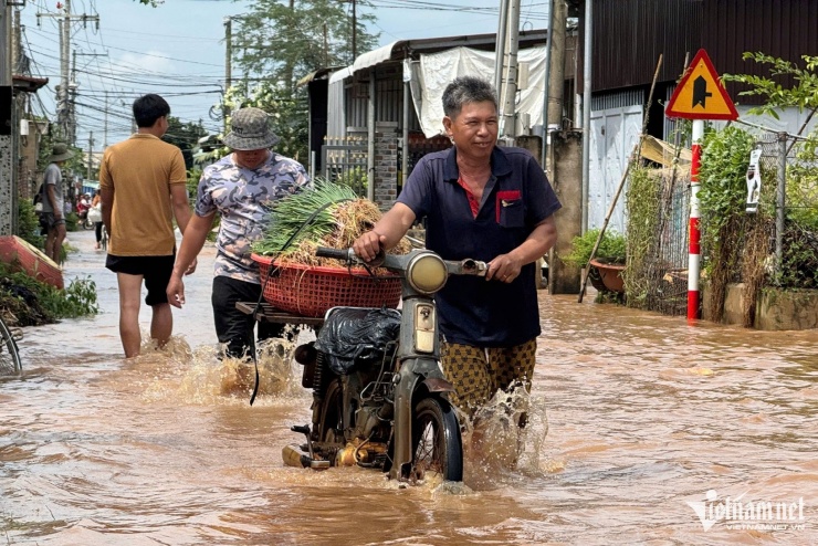 Ghi nhận của PV VietNamNet, lúc 11h cùng ngày, tại khu vực phía sau nhà thờ Phúc Nhạc (xã Gia Kiệm), nước ngập sâu hơn nửa bánh xe máy, nhiều đoạn đường trở thành “biển nước”. Người dân phải dắt xe, lội nước giữa dòng nước chảy xiết để về nhà.