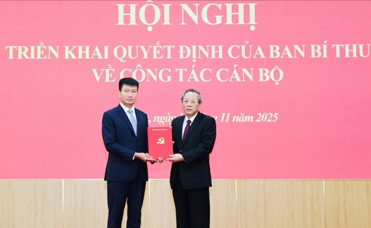Ông Hoàng Đăng Quang - Ủy viên Trung ương Đảng, Phó trưởng Ban Thường trực Ban Tổ chức Trung ương - trao quyết định cho ông Trần Huy Tuấn (bên trái). Ảnh: Báo Ninh Bình.