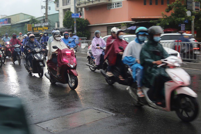 Người dân di chuyển trên đường mưa kéo dài thêm vất vả