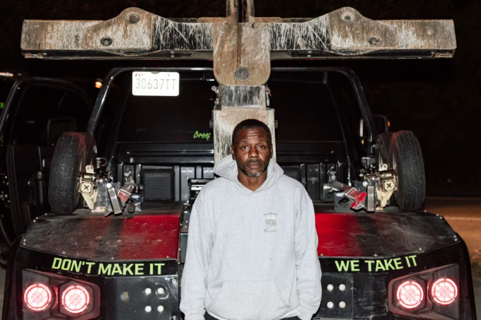 George Dowdy, một nhân viên thu hồi xe quá hạn trả nợ trong một ca làm việc, tháng 10/2025. Sau xe anh có dòng chữ Don't make it, we take it (tạm dịch Bạn không trả, chúng tôi sẽ lấy) Ảnh: WSJ