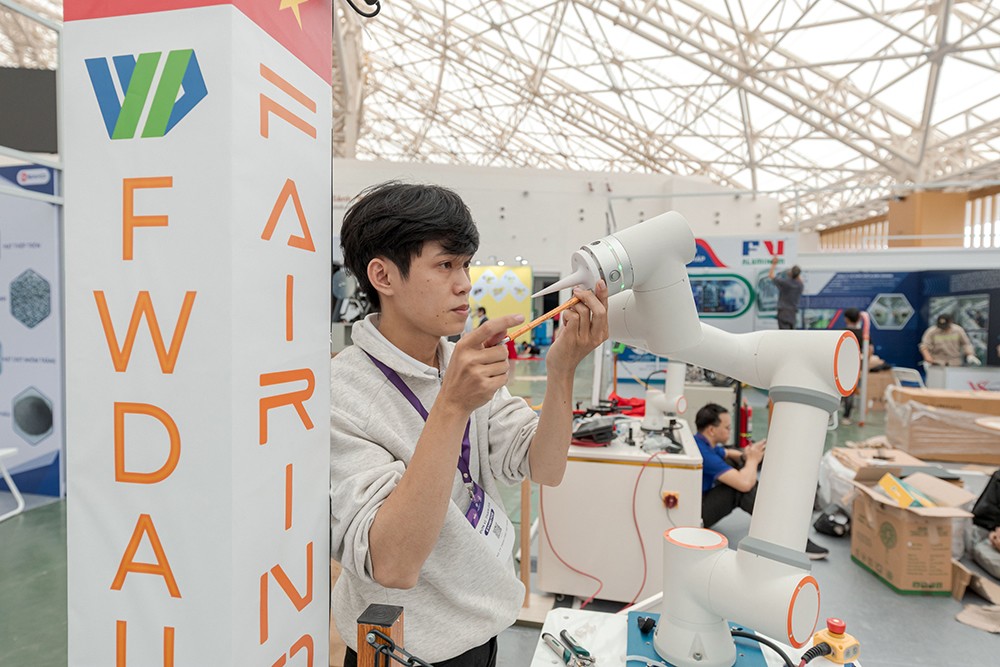 Một kỹ sư đang lắp đặt thiết bị in 3D tại không gian trưng bày Tuần lễ Công nghiệp & Công nghệ Việt Nam 2025