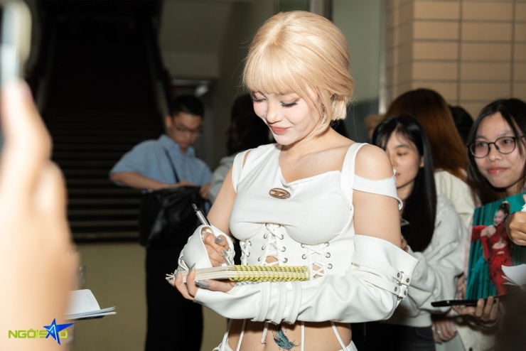 Khi vừa đến thảm đỏ, ca sĩ được người hâm mộ reo hò và xin chữ ký.