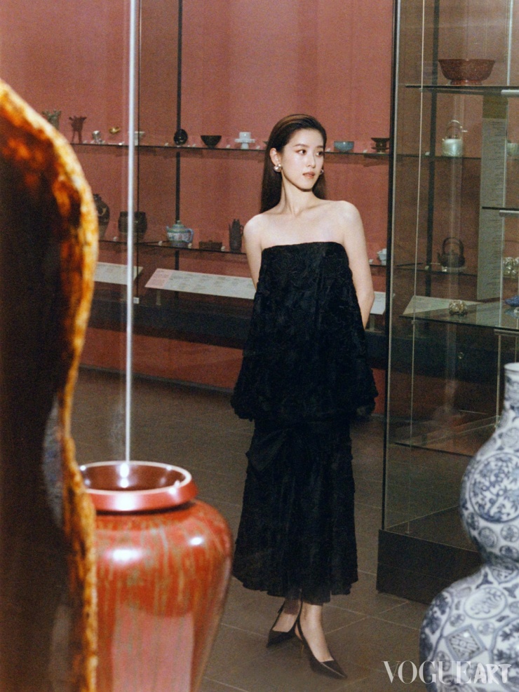 Trạch Thiên tạo dáng bên các cổ vật ở một triển lãm.