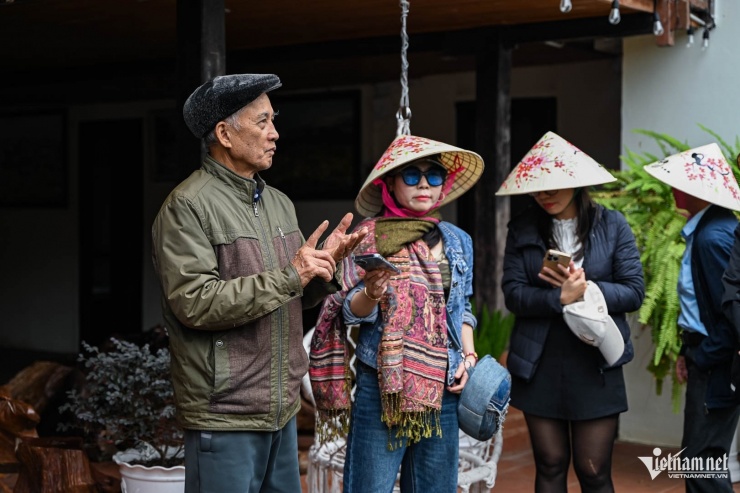 Ông Chài đón đoàn khách tới tham quan ngôi nhà sàn gần trăm tuổi. Ảnh: Huy Nguyễn