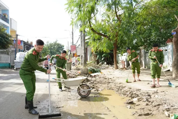 Các chiến sĩ công an tham gia dọn dẹp vệ sinh sau lũ ở Huế. Ảnh: NGUYỄN DO